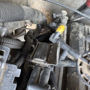 Engine bay wiring and bracket detail during a repair