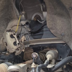 Front lower control arm and suspension components under a vehicle on a lift