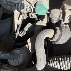 Cooling system hose and thermostat housing during a coolant repair