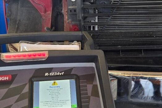 R-1234yf air conditioning refrigerant recovery machine in use on a vehicle in the service bay