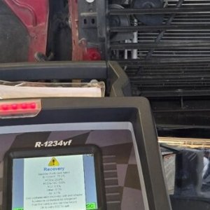 R-1234yf air conditioning refrigerant recovery machine in use on a vehicle in the service bay