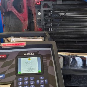 R-1234yf air conditioning refrigerant recovery machine in use on a vehicle in the service bay