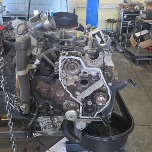 Removed diesel engine with the front cover opened up for internal repairs