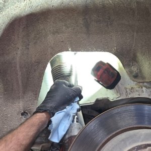 Technician cleaning a new brake rotor before installing the wheel
