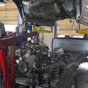 Ram pickup raised on a lift while the engine and transmission are removed from underneath