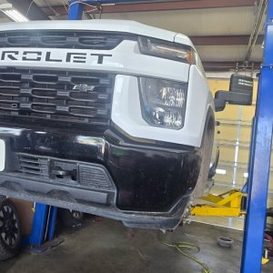 Chevrolet Silverado raised on a two-post lift in the service bay